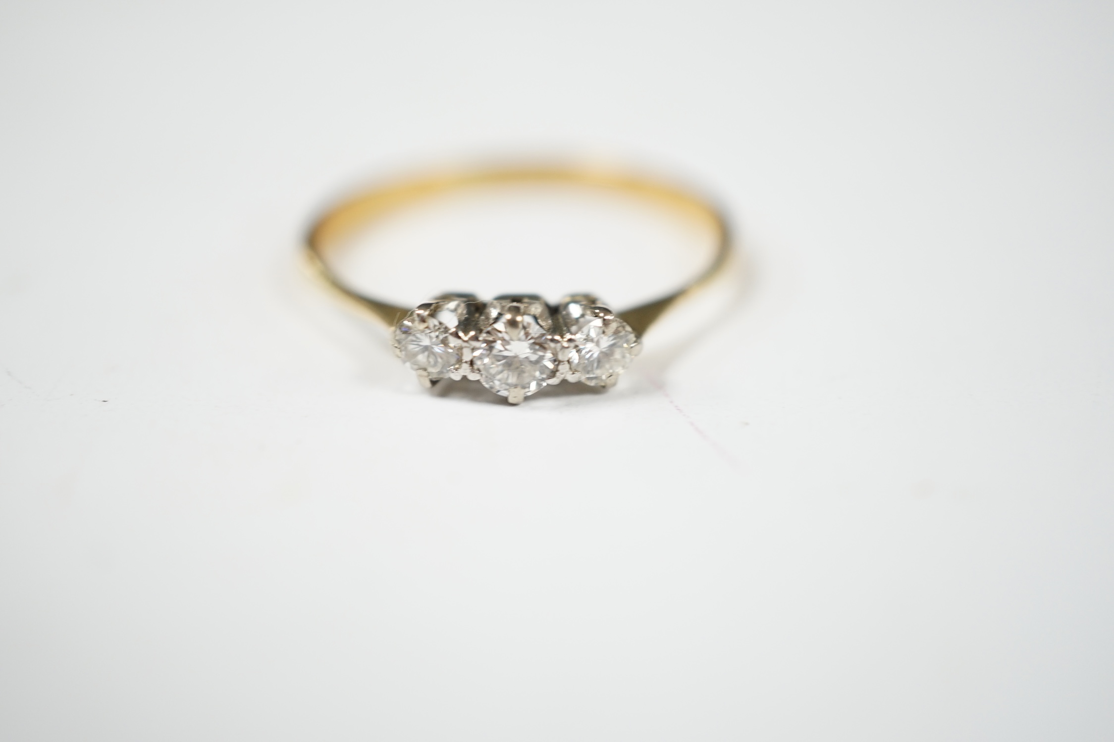 A yellow metal and three stone diamond set ring, size V, gross weight 2.4 grams. Condition - fair